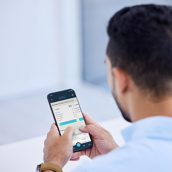 giovane uomo felice con in mano il cellulare che sta usando 2tick